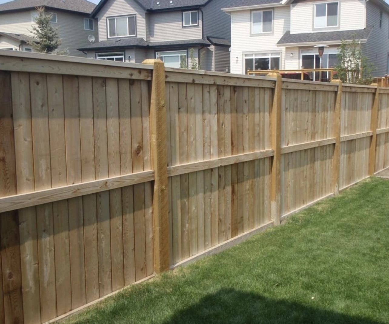 Four-rail wood fence beside stone entry