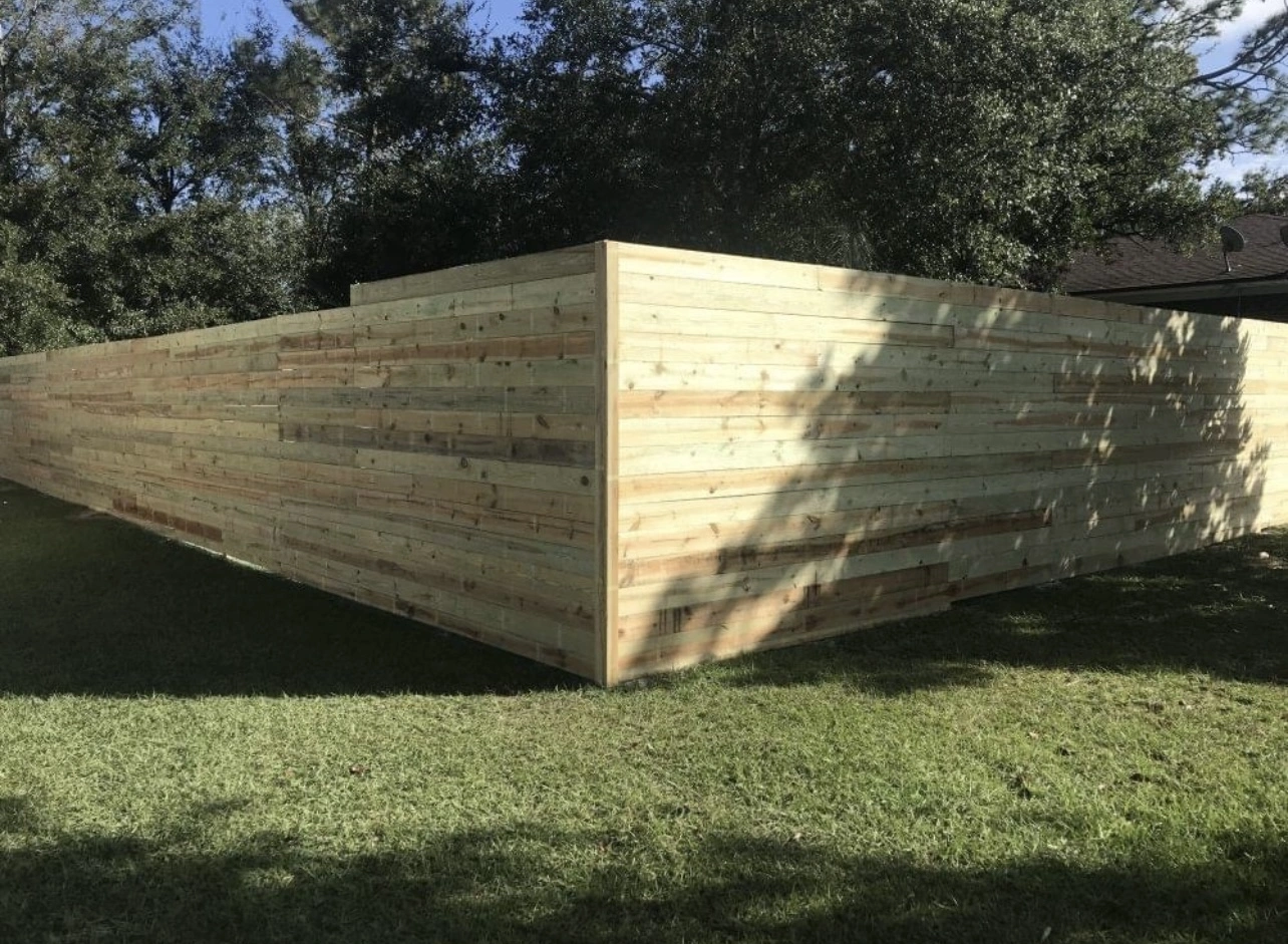 Long horizontal privacy fence run on lawn